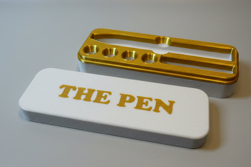 White and gold KwikPen case with 'THE PEN' engraving in a gold on white background