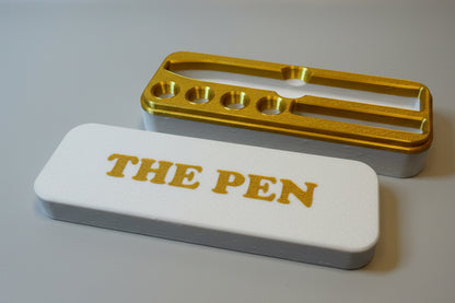 White and gold KwikPen case with 'THE PEN' engraving in a gold on white background